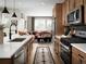 Open kitchen boasts modern appliances and wood cabinets, with a view into the living room at 2515 W 69Th Pl, Denver, CO 80221