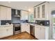 Modern kitchen featuring white cabinets, stainless steel appliances, and a blue subway tile backsplash at 9430 Carr St, Westminster, CO 80021