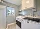 Laundry room featuring side-by-side washer and dryer, storage cabinets and a window at 9430 Carr St, Westminster, CO 80021