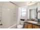 Well-lit bathroom with a tiled shower/tub, wooden vanity, and a window for natural light at 1698 Odyssey Ct, Castle Rock, CO 80109