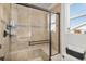 Tiled walk-in shower with a glass door and bench, accompanied by a view of the toilet and toilet paper holder at 1698 Odyssey Ct, Castle Rock, CO 80109