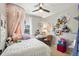 Bright bedroom featuring a bed with whimsical decor, a cozy desk area, and ample natural light at 1698 Odyssey Ct, Castle Rock, CO 80109