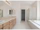 Bathroom with a tile floor, tile counters and a tub with a glass shower door at 5204 Shetland Ct, Highlands Ranch, CO 80130
