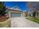 Charming brick home with a two-car garage and manicured lawn under a clear blue sky at 5204 Shetland Ct, Highlands Ranch, CO 80130