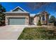 Charming brick home featuring an attached two-car garage, manicured lawn and beautiful front yard landscaping at 5204 Shetland Ct, Highlands Ranch, CO 80130