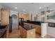 Traditional kitchen with wood cabinets, black countertops, and hardwood floors at 5204 Shetland Ct, Highlands Ranch, CO 80130