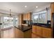 Open concept kitchen with wood cabinets, hardwood floors, black countertops, an island and a door to the outdoor deck at 5204 Shetland Ct, Highlands Ranch, CO 80130