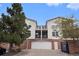 Exterior of townhome featuring a two-car garage, brick accents, and neutral siding at 1646 S Deframe St # B8, Lakewood, CO 80228