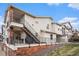 Exterior view of a modern townhouse featuring a private patio, stairs, and brick foundation at 1646 S Deframe St # B8, Lakewood, CO 80228