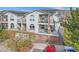 View of townhouses with balconies, stairs, brick accents, and a red car parked nearby at 1646 S Deframe St # B8, Lakewood, CO 80228