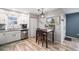 Well-lit dining area with a modern light fixture adjacent to a kitchen area with stainless steel appliances at 1646 S Deframe St # B8, Lakewood, CO 80228