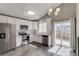 Modern kitchen with stainless steel appliances, white cabinets, and gray wood flooring at 3969 S Fundy Cir, Aurora, CO 80013