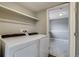 Well-equipped laundry room featuring a modern washer and dryer with an open doorway to another room at 3969 S Fundy Cir, Aurora, CO 80013