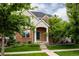 Charming brick home with a well-manicured front yard and inviting green front door at 8122 E 6Th Pl, Denver, CO 80230