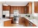 Well-equipped kitchen featuring stainless steel appliances, custom cabinetry, and white backsplash for a clean design at 8122 E 6Th Pl, Denver, CO 80230