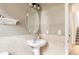 Charming powder room with a pedestal sink, tile accent wall, and decorative mirror at 8122 E 6Th Pl, Denver, CO 80230