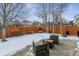 Snow-covered backyard with patio and wooden fence at 2400 S Halifax Way, Aurora, CO 80013