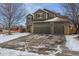 Two-story home with a three-car garage and snow-covered driveway at 2400 S Halifax Way, Aurora, CO 80013