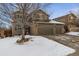 Two-story house with a three-car garage and snow-covered front yard at 2400 S Halifax Way, Aurora, CO 80013