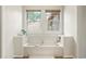Clean bathroom with a soaking tub, white tiles, and modern fixtures at 6664 S Webster St, Littleton, CO 80123