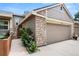 Exterior side view of townhome garage with brick accents and walkway at 6664 S Webster St, Littleton, CO 80123
