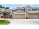 Exterior view of a two-story townhome with a two-car garage and beautiful stone accents at 6664 S Webster St, Littleton, CO 80123