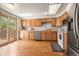 Spacious kitchen with wood cabinets, stainless appliances, and access to outdoor deck at 6664 S Webster St, Littleton, CO 80123