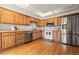 Charming kitchen features wood cabinets, stainless steel appliances, and hardwood floors at 6664 S Webster St, Littleton, CO 80123