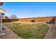 This backyard is surrounded by a tall wooden fence and includes a bbq grill and basketball hoop at 5556 Lewiston Ct, Denver, CO 80239