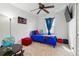 This cozy bedroom includes a blue bed, flat screen tv and ceiling fan at 5556 Lewiston Ct, Denver, CO 80239