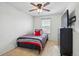 A simple bedroom with a striped bedspread, ceiling fan, dresser, and flat screen tv at 5556 Lewiston Ct, Denver, CO 80239