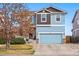 Charming two-story home with a blue garage door and complementary brown siding accents at 5556 Lewiston Ct, Denver, CO 80239