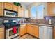 Well-lit kitchen featuring modern appliances, light wood cabinets, and beautiful tile accents at 5556 Lewiston Ct, Denver, CO 80239