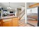 Open kitchen view, adjacent to the stairs and living room, featuring stainless steel refrigerator at 5556 Lewiston Ct, Denver, CO 80239