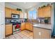 Kitchen featuring tile counters, stainless steel appliances, and wooden cabinetry at 5556 Lewiston Ct, Denver, CO 80239