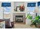 Living room with a tiled fireplace, mantle decorations, and bright windows with matching valences at 5556 Lewiston Ct, Denver, CO 80239