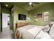 Green bedroom with a queen bed, TV, and an open doorway leading to the rest of the home at 4925 W 10Th Ave # 111, Denver, CO 80204