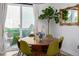 Bright dining area with round wooden table, green chairs, and sliding glass door to outdoor seating at 4925 W 10Th Ave # 111, Denver, CO 80204