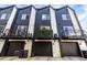 Modern townhouse exteriors featuring black and white facade, garages, and balconies at 4925 W 10Th Ave # 111, Denver, CO 80204