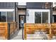 Close up of a modern townhome's front door, accented by a wreath and wood fencing at 4925 W 10Th Ave # 111, Denver, CO 80204