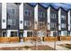 Modern townhome exteriors showcase black and white siding, a small tree, and wood accents at 4925 W 10Th Ave # 111, Denver, CO 80204