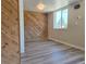Bright bedroom with hardwood style flooring and unique wooden paneling accent wall at 3225 S Garrison St # 19, Lakewood, CO 80227