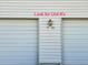 Exterior shot of a building with marked garage doors, indicating unit numbers, and a lantern at 3225 S Garrison St # 19, Lakewood, CO 80227