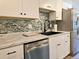 Bright kitchen with white cabinets, marble countertops, and a blue mosaic tile backsplash at 3225 S Garrison St # 19, Lakewood, CO 80227