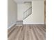 Living room with wood-look flooring and a staircase with a black metal railing and carpeted steps at 3225 S Garrison St # 19, Lakewood, CO 80227