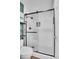 Modern bathroom featuring a stylish glass-enclosed shower, black hardware, and tiled flooring at 7891 Allison Way # 201, Arvada, CO 80005