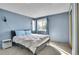 Comfortable bedroom with blue walls, a large window, and soft natural light, creating a peaceful ambiance at 7891 Allison Way # 201, Arvada, CO 80005