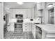 Modern kitchen with stainless steel appliances, white cabinets and custom backsplash at 7891 Allison Way # 201, Arvada, CO 80005