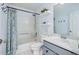 This bathroom has a shower-tub combo with tile surround, stylish shower curtain and vanity for a serene and updated feel at 317 Bonanza Dr, Erie, CO 80516
