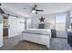 Serene bedroom features a bed with a rustic wood frame, ceiling fan, and barn door to the bath at 317 Bonanza Dr, Erie, CO 80516